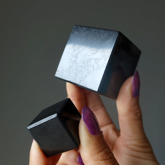 hands holding two shungite cube