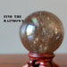 smoky quartz sphere on wood stand with rainbow sheen