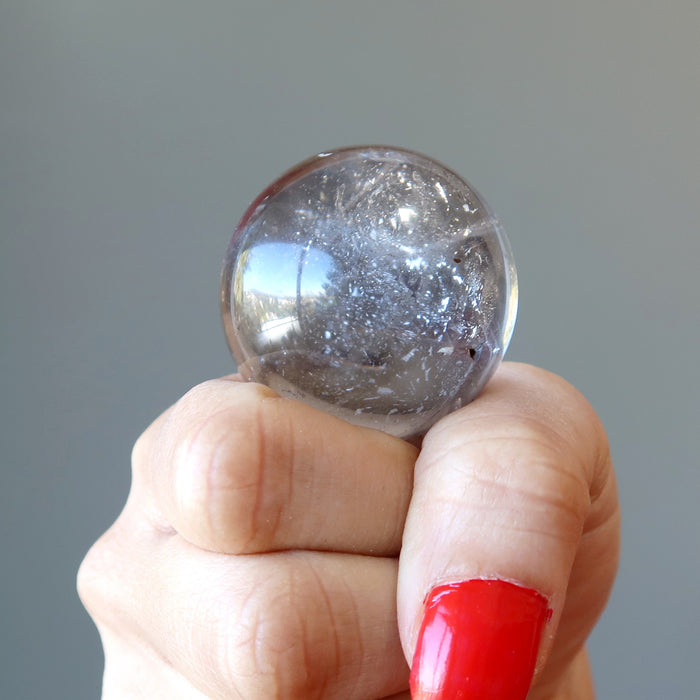 hand holding smoky quartz sphere
