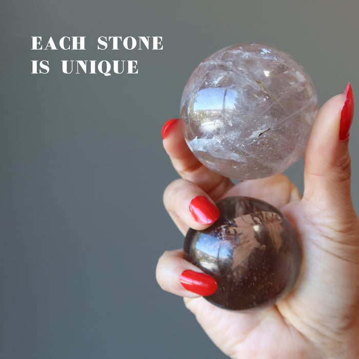 hand holding two Smoky Quartz Spheres showing each is unique