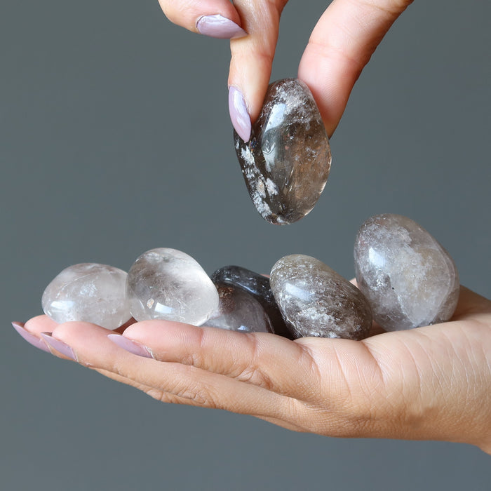 sheila of satin crystals picking one of  Smoky Quartz Tumbled Stones from her palm