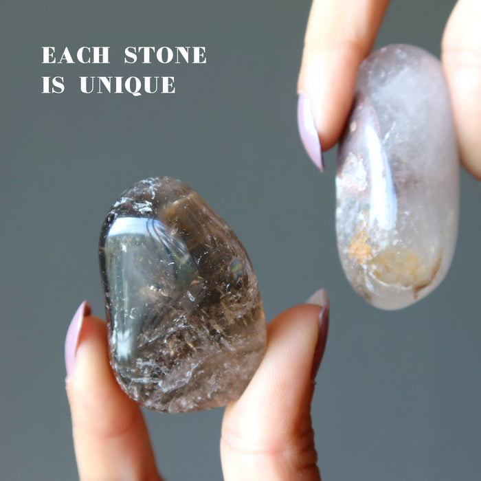 holding two smoky quartz tumbled stones showing each stone is unique 
