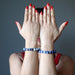 lady modeling sodalite bracelets on both hands, one on each wrist