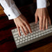hands typing on a keyboard wearing sodalite cufflinks