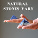 hands holding two sodalite pyramids