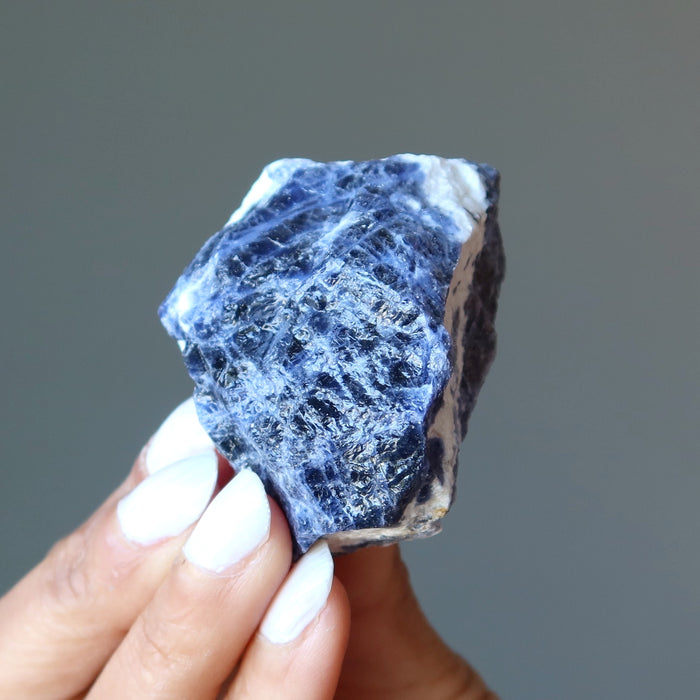 holding Raw Sodalite Crystal with finger tips