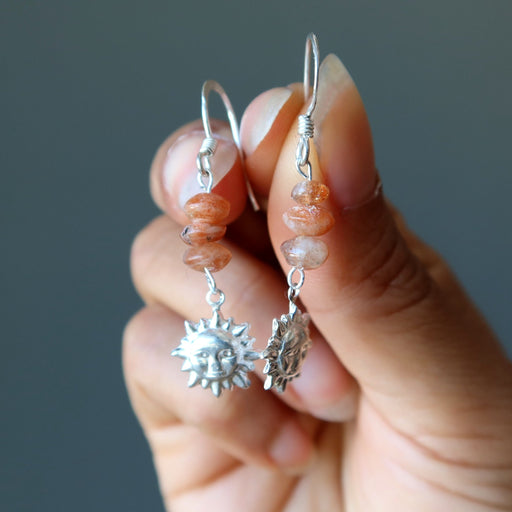 hand holding sunstone sterling silver sun earrings