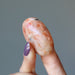 finger tips holding Sunstone Palm Stone