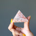 hand holding sunstone pyramid