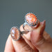 holding two Sunstone Rings
