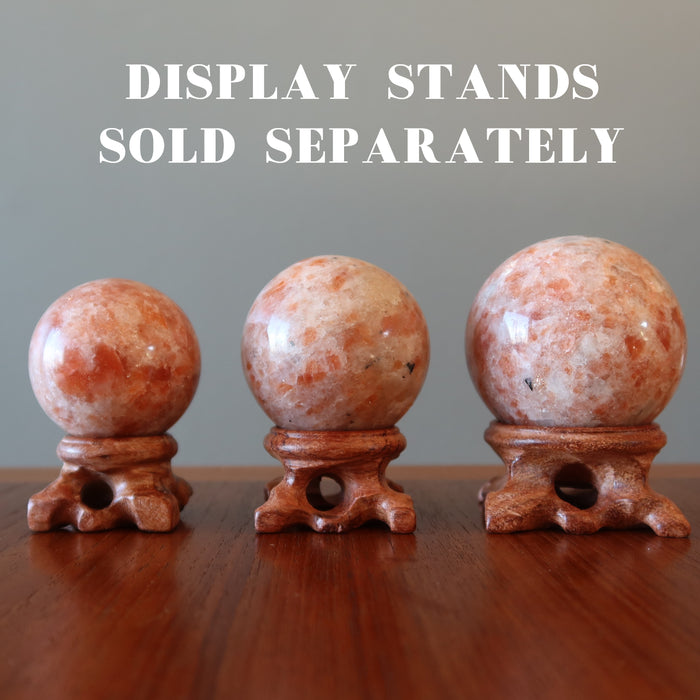 three sunstone spheres on wood display stands, stands sold separately