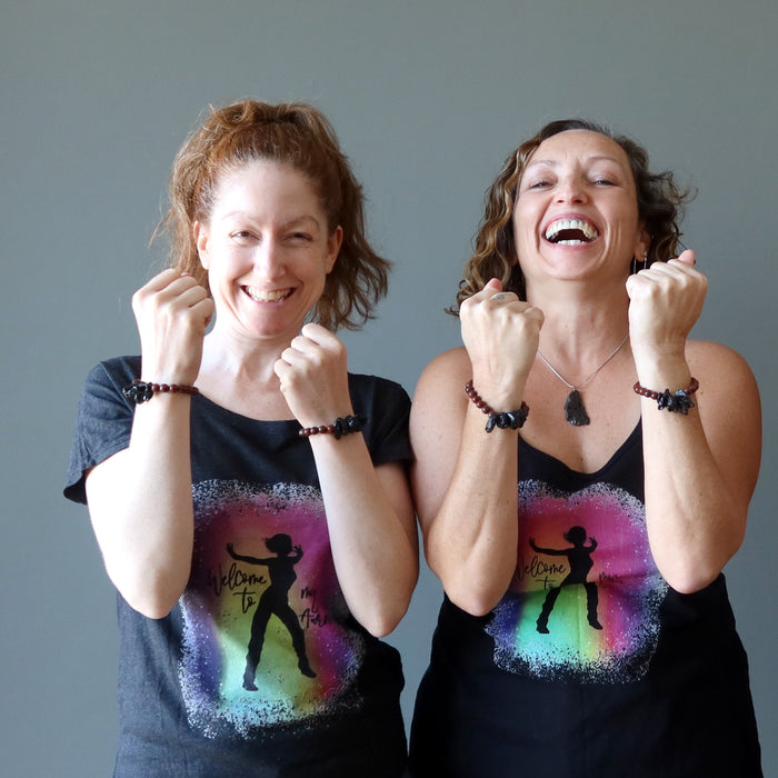 two females wearing tektite obsidian bracelets and satin crystals shirts