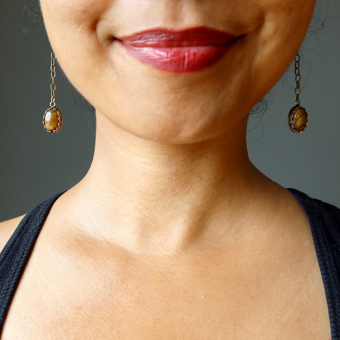 sheila of satin crystals wearing long golden brown tigers eye oval stones in antique brass chain earrings