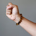 fist wearing golden brown tigers eye round stretch bracelet