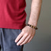 mans hand in pocket wearing golden brown tigers eye round stretch bracelet