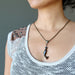 model wearing tigers eye dolphin and black ball pendant on thick metal necklace