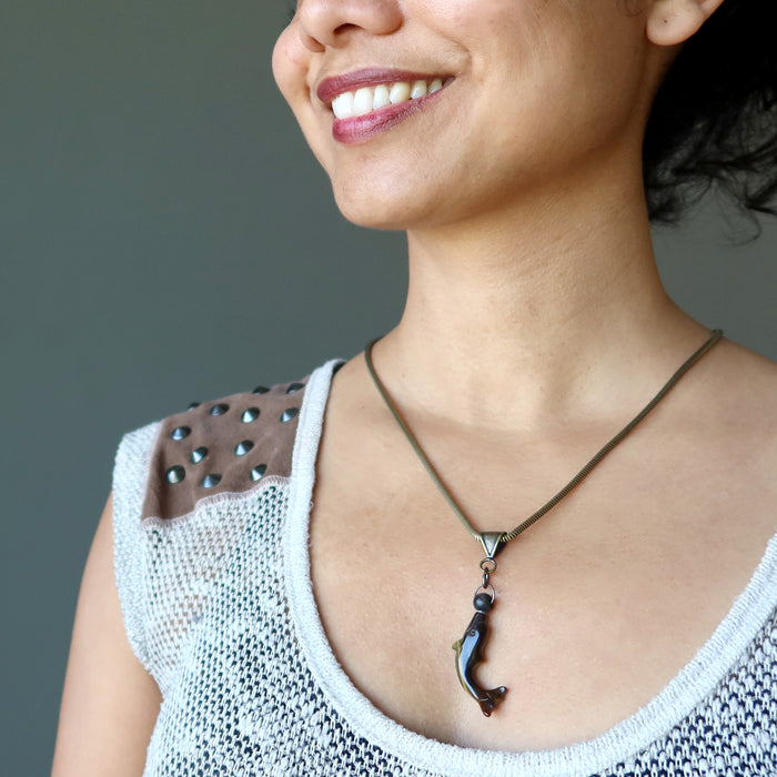 model wearing tigers eye dolphin and black ball pendant on thick metal necklace