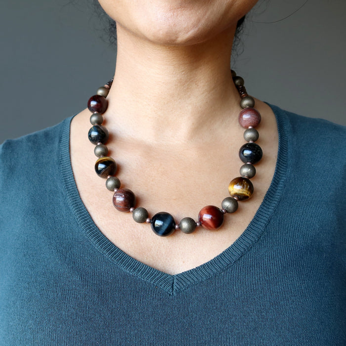 woman of satin crystals wearing golden, blue and red tigers eye on antiqued beaded necklace