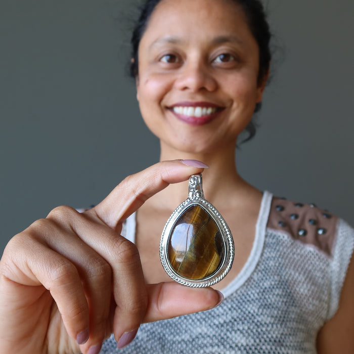 sheila of satin crystals holding golden brown tigers eye teardrop in silver pendant