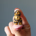finger tips holding a 1" Tigers Eye Rabbit