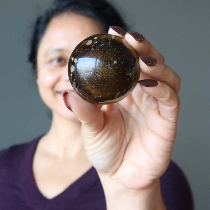 sheila of satin crystals holding Den Muddy Earth Tigers Eye Sphere