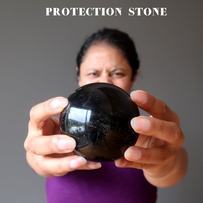 sheila of satin crystals holding a black tourmaline sphere