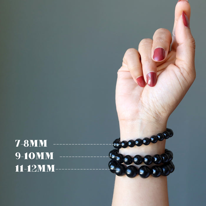 hand wearing three sizes of black tourmaline bracelets
