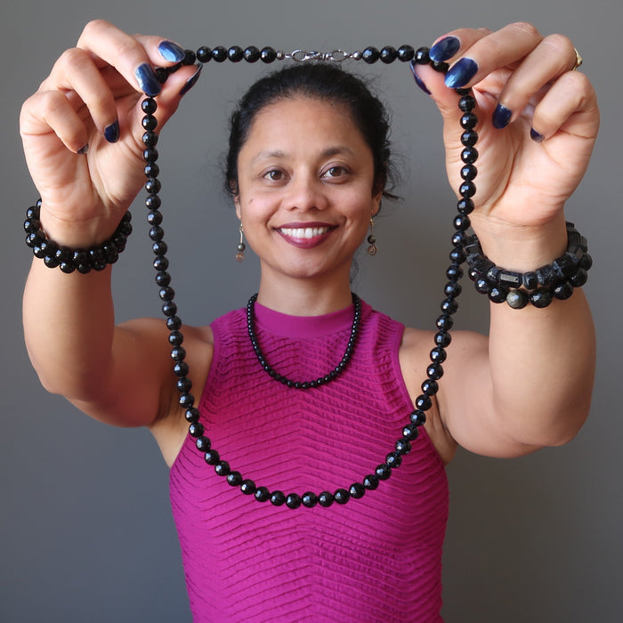 sheila of satin crystals wearing and holding faceted Black Tourmaline round beaded Necklace 