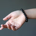 hand wearing a faceted black tourmaline stretch bracelet