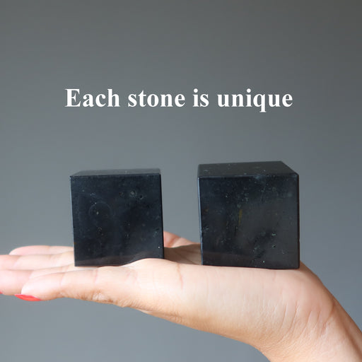 two black tourmaline cubes in hand