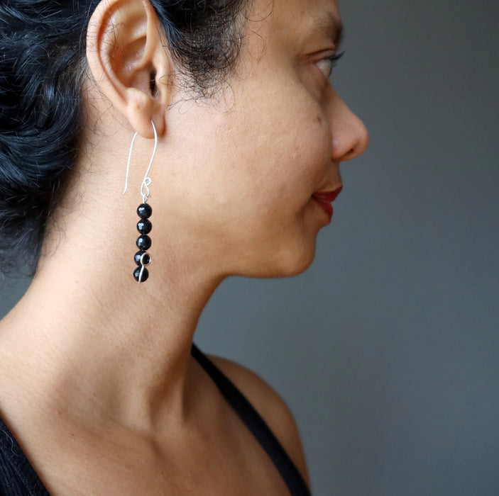 female wearing faceted black tourmaline earring