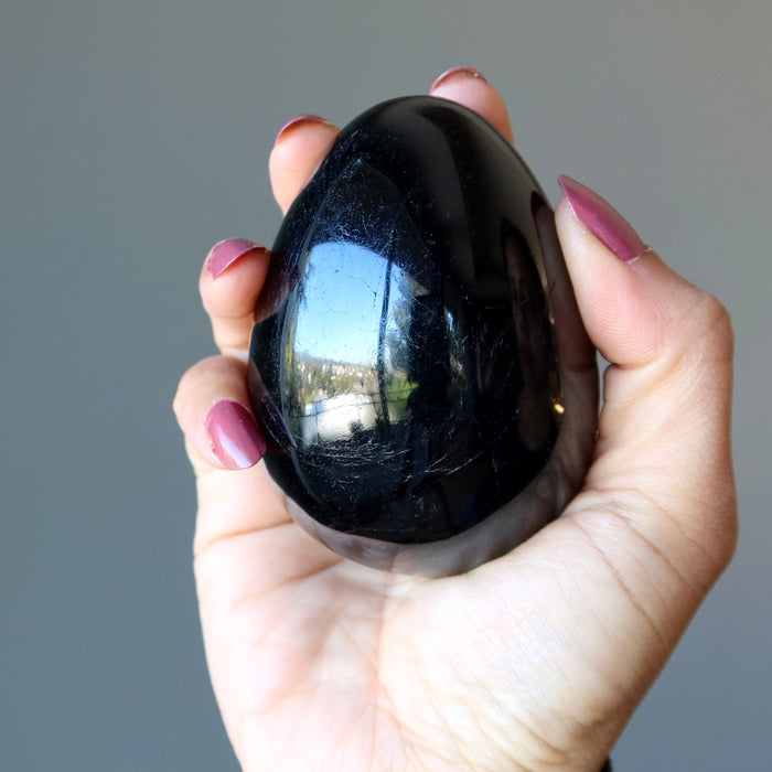 hand holding black tourmaline egg