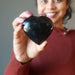 woman holding black tourmaline heart 