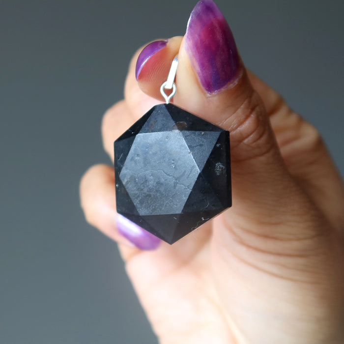 hand holding black tourmaline hexagon pendant