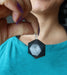 black tourmaline hexagon pendant at chest