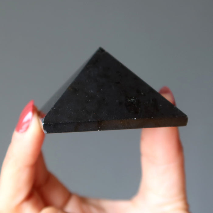 hand holding black tourmaline pyramid