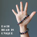 hand wearing two multi colored tourmaline stretch bracelets to show varying colors