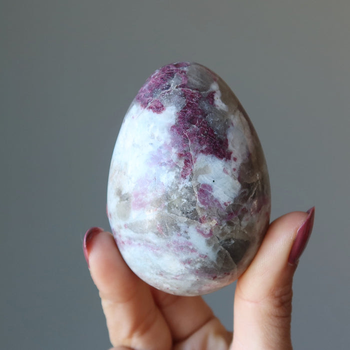 red tourmaline egg in hand