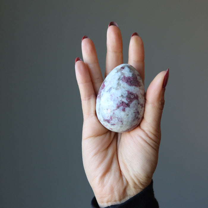 red tourmaline egg in palm of hand