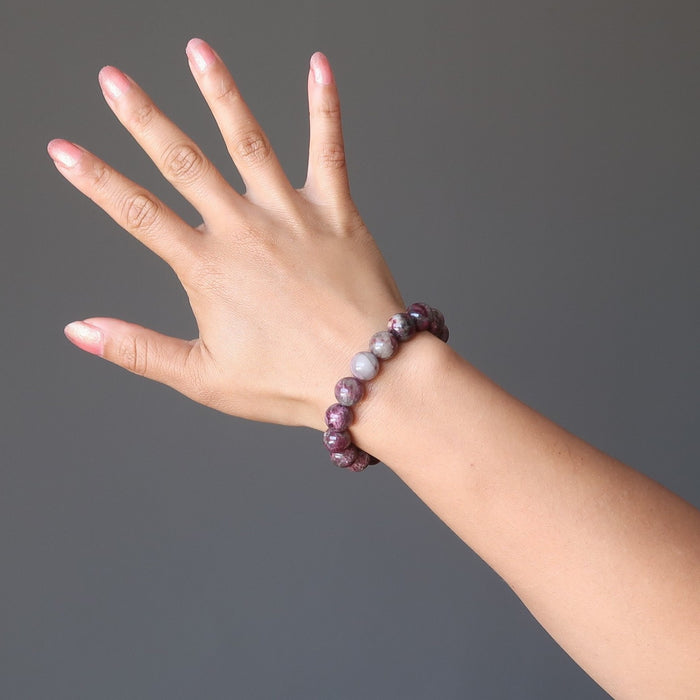A round beaded pink Tourmaline bracelet on a model's hand