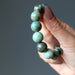 hand holding african turquoise bracelet 