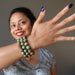 sheila of satin crystals wearing 3 green and brown turquoise jasper round beaded stretch bracelets