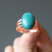 hand holding a turquoise copper ring