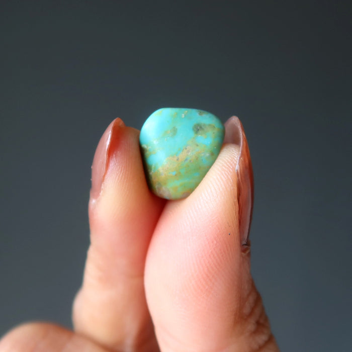 tumbled turquoise stone in hand