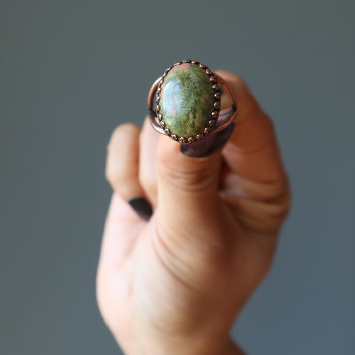 hand holding unakite oval antique copper adjustable ring