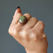 fist wearing unakite oval antique copper adjustable ring on middle finger