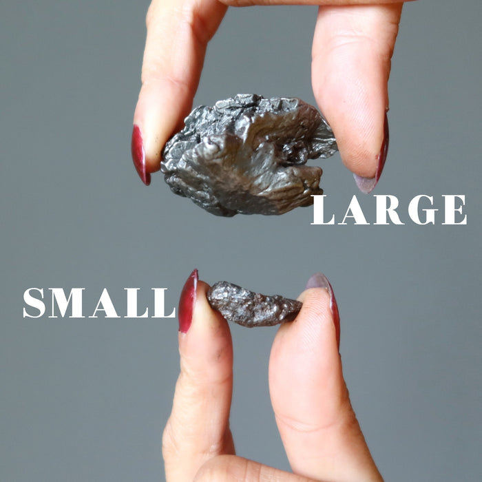 hand holding uruaca meteorites showing small and large sizes