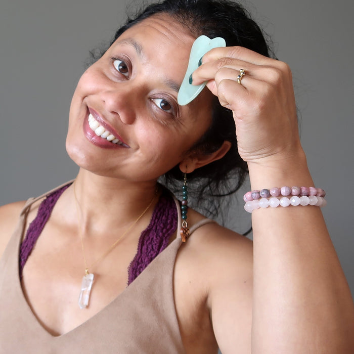 sheila of satin crystals using a jade scraper for guasha on her forehead