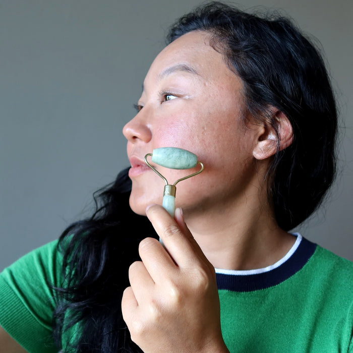 jessica of satin crystals using a jade roller on her cheek